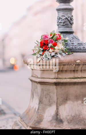 Beau bouquet de mariage avec des roses rouges et roses pivoines sur vintage lanterne baroque dans le vieux centre-ville Banque D'Images