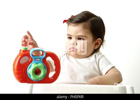 Onze mois bébé fille avec son premier appareil photo jouet Banque D'Images