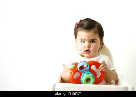 Onze mois bébé fille avec son premier appareil photo jouet Banque D'Images