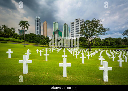 Tombes et les bâtiments modernes dans la distance à la manille Cimetière Américain et Mémorial, à Taguig, Metro Manila, Philippines Banque D'Images