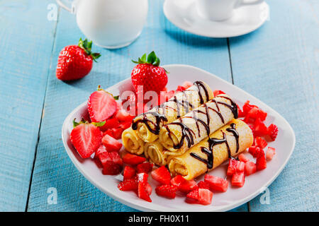 Crêpes roulées avec des fraises et du chocolat petit déjeuner Banque D'Images