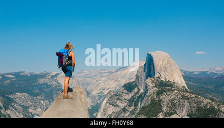 Randonneur debout sur une falaise, surplombant Demi Dôme, vue de Glacier Point, Yosemite National Park, California, USA Banque D'Images