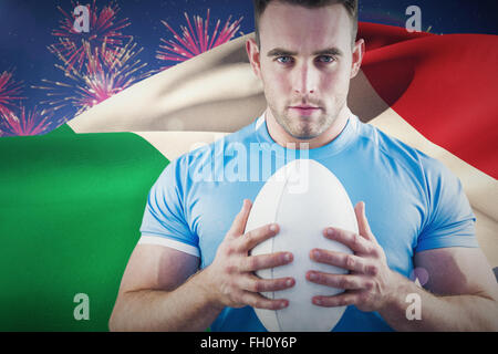 Image composite de rugby player looking at camera with ball Banque D'Images