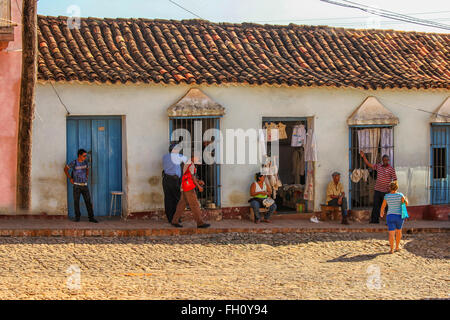 Les gens qui achètent les vêtements à des boutiques dans une rue de Trinidad, Cuba. Banque D'Images