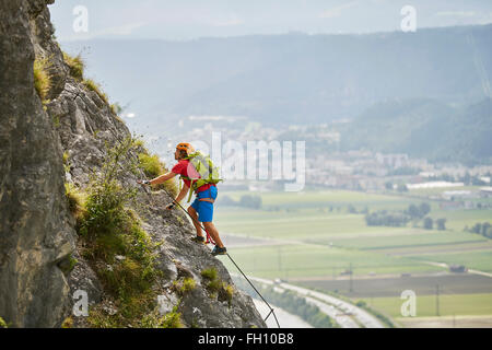 Grimpeur, alpiniste avec orange helmet l'ascension de la via ferrata, Zirl, Innsbruck, Tyrol, Autriche Banque D'Images