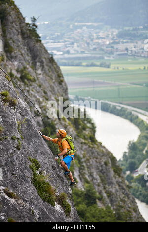 Grimpeur, alpiniste avec orange helmet l'ascension de la via ferrata, Zirl, Innsbruck, Tyrol, Autriche Banque D'Images