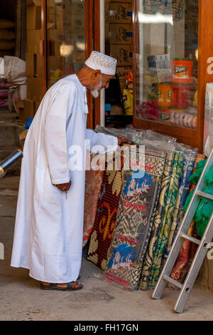 Un vieil homme omanais à tapis/tapis dans le Souk de Nizwa Nizwa, Ad Dakhiliyah, région, Oman Banque D'Images