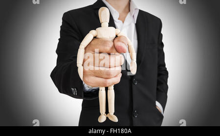 Businessman holding figure en bois, concept abstrait Banque D'Images