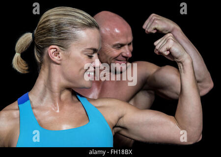 Heureux homme en bonne santé et woman flexing muscles Banque D'Images