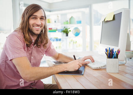 Hipster heureux de travailler sur tablette graphique et l'ordinateur Banque D'Images