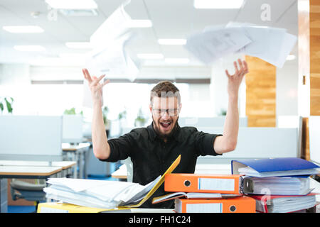 Angry businessman assis à la table et de crier in office Banque D'Images