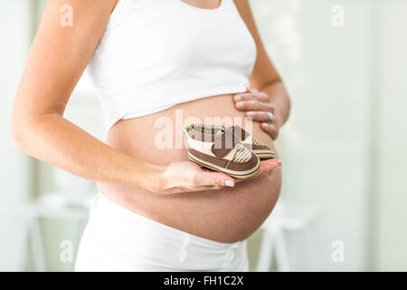 Portrait de femme avec des bottes bébé dans la main Banque D'Images