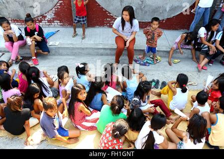 L'adolescent dynamique Company (DTC) Tête Site Marline Portacio évalué les enfants pour ce qu'ils ont appris dans leurs classes pour la journée au cours de l'Klasrum Kariton Pushcart (Classe) menée en Brgy. 5, rue d'Alonzo, Dalahikan, Cavite City. Les fondateurs de DTC s'épanouir comme ils grandissent lentement le nombre de jeunes d'être transformés par l'intermédiaire de leurs programmes. Transformé les jeunes, qui utilisé pour être les utilisateurs de drogue, petits voleurs, les détritivores, enfants des rues, les décrocheurs et les jeunes non scolarisés sont maintenant DTC bénévoles et sont retournés à l'enseignement ordinaire. Bien que certains des enfants ne sont pas Banque D'Images