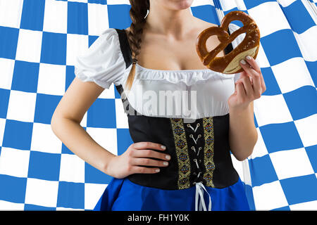 Image composite de jolie oktoberfest girl holding pretzel Banque D'Images