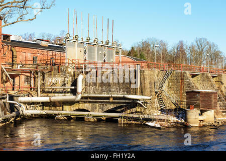 Une usine de papier abandonnés à proximité d'une rivière. L'usine est lentement en train de s'effondrer. Voici un détail d'un barrage avec de l'eau soulevée gates Banque D'Images