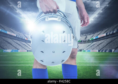 Image composite du milieu du joueur de football américain de remettre son casque Banque D'Images