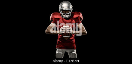 Composite image of american football player en maillot rouge et helmet holding ball Banque D'Images