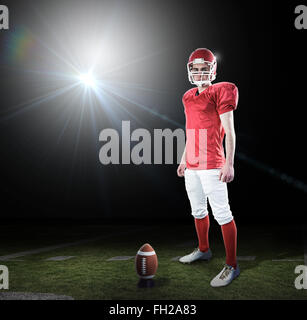 Image composite d'un joueur de football américain en tenant son casque looking at camera Banque D'Images