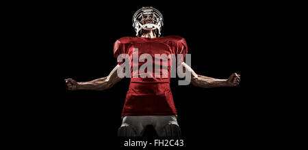 Image composite de joueur de football américain agressif en maillot rouge hurlant Banque D'Images