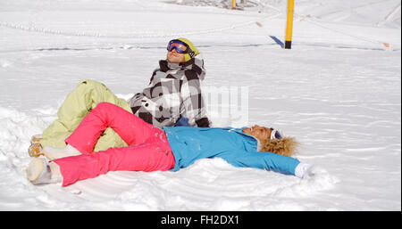 Couple resting on hill après le ski Banque D'Images