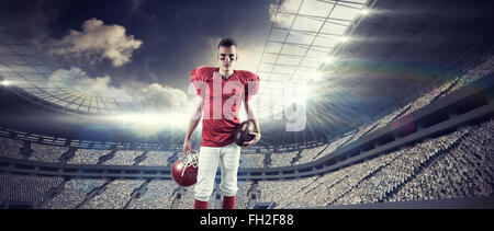 Image composite d'un joueur de football américain en tenant son casque sur sa main à la camer à Banque D'Images