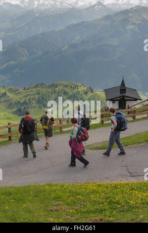 Un groupe de randonneurs passant une petite église sur le Kitzbuheler Horn à Kitzbuhel, Autriche. L'Europe Banque D'Images