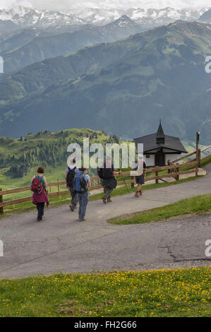 Un groupe de randonneurs passant une petite église sur le Kitzbuheler Horn à Kitzbuhel, Autriche. L'Europe Banque D'Images