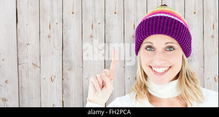 Image composite de femme positive montrant up smiling at the camera against white background Banque D'Images