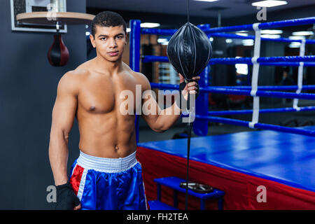 Beau mâle boxer debout dans une salle de sport et looking at camera Banque D'Images