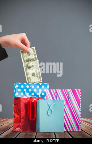 Image composite de businesswomans hand holding hundred dollar bill Banque D'Images