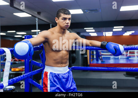 Male boxer debout dans le coin du ring de boxe Banque D'Images