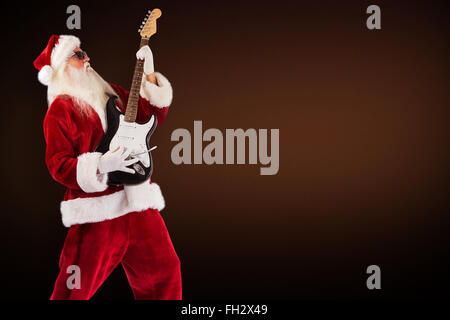 Image composite de santa playing electric guitar Banque D'Images