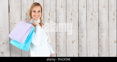 Composite image of woman holding shopping bags against white background Banque D'Images