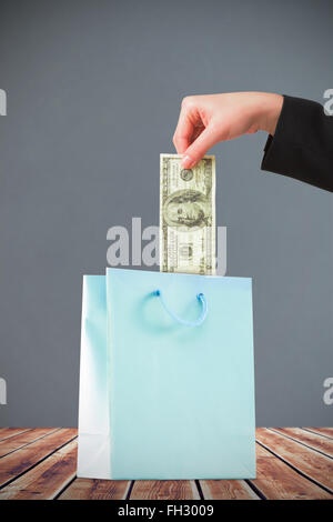 Image composite de businesswomans hand holding hundred dollar bill Banque D'Images