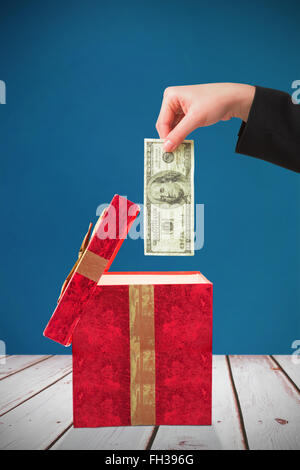 Image composite de businesswomans hand holding hundred dollar bill Banque D'Images