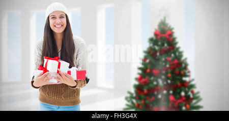 Image composite des fêtes de brunette holding gifts Banque D'Images