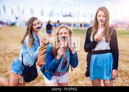 Teenage girls at Summer festival avec fake moustache Banque D'Images