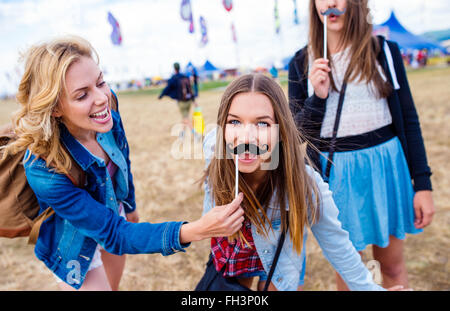 Teenage girls at Summer festival avec fake moustache Banque D'Images