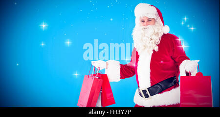 Portrait of santa claus holding shopping bags Banque D'Images