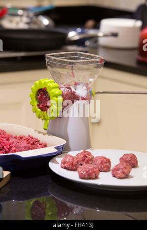 À l'aide d'un hachoir pour hacher la viande bovine domestique puis faire des boulettes de viande dans une cuisine familiale Banque D'Images