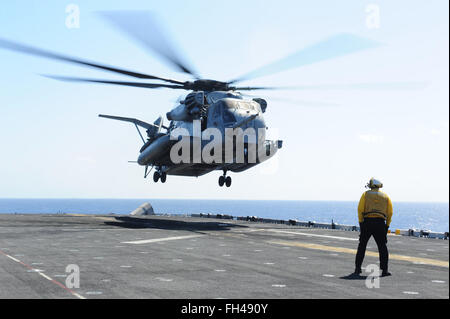 Océan Pacifique (fév. 22, 2016) l'Aviation maître de Manœuvre (manutention) Ballard-Henry Nicholas signale un CH-53E Super Stallion, affecté à l'Escadron du rotor d'inclinaison moyenne Marine (VMM) 166 (renforcée), sur l'envol du navire d'assaut amphibie USS Boxer (DG 4). Plus de 4 500 marins et Marines du groupe amphibie Boxer et la 13e Marine Expeditionary Unit (13e MEU) ont entrepris de soutien la formation au large de la côte d'Hawaï en préparation dans les 5e et 7e flotte secteurs d'opérations. Banque D'Images