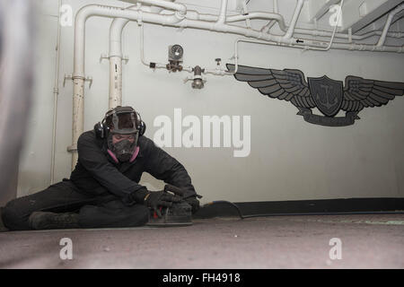 YOKOSUKA, Japon (fév. 22, 2016) Tyler Seaman Finley, de McMinnville, Oregon, utilise un deck crawler pour dépouiller le pont dans le gaillard, à bord de la Marine américaine est que l'avant-déployé porte-avions USS Ronald Reagan (CVN 76). Ronald Reagan fournit une force prête au combat qui protège et défend les intérêts de maritime collective de ses alliés et partenaires dans la région du Pacifique-Indo-Asia. Banque D'Images