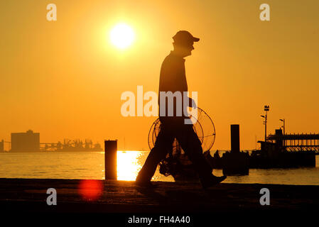 Lisbonne, Portugal. 14 Décembre, 2015. Un pêcheur portant un filet le long d'une jetée à côté du Tage à Lisbonne, Portugal, le 14 décembre 2015. Photo : Hauke Schroeder - PAS DE FIL - SERVICE/dpa/Alamy Live News Banque D'Images