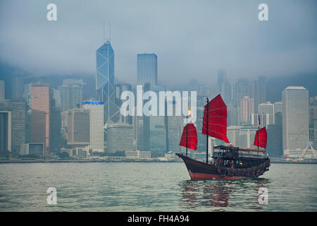 Hong Kong, Chine. Navigation le long Junkboat Hong Kong Hong Kong Skyline en un jour brumeux. Banque D'Images