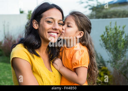 Jolie fille de l'embrasser la joue les mères Banque D'Images