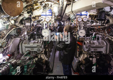 Photographies d'un visiteur la salle des machines à bord du sous-marin HMS WWII Alliance en cale sèche à Gosport, Banque D'Images