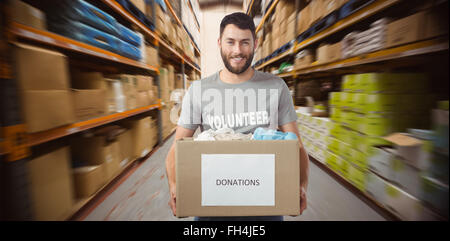 Image composite de portrait of man holding clothes donation box in office Banque D'Images