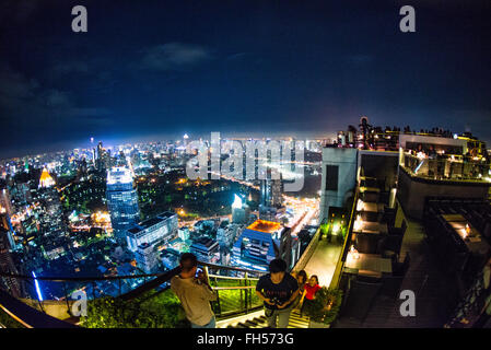 BANGKOK, Thaïlande — les gratte-ciel nocturnes scintillants de Bangkok s'étendent en contrebas, vu du restaurant Vertigo situé sur le toit du Banyan Tree Hotel. Gratte-ciel et gratte-ciel illuminent l'immense capitale thaïlandaise d'innombrables lumières, créant un panorama urbain éblouissant. Banque D'Images