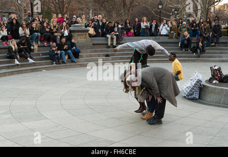 Performance de rue à Washington Square Park d'acrobat somersaulting plus de bénévoles avec des foules de spectateurs Banque D'Images