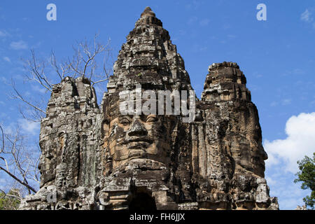 Visages de pierre sculptés ornent la porte d'entrée à l'ensemble du temple Bayon, Angkor Wat, au Cambodge Banque D'Images